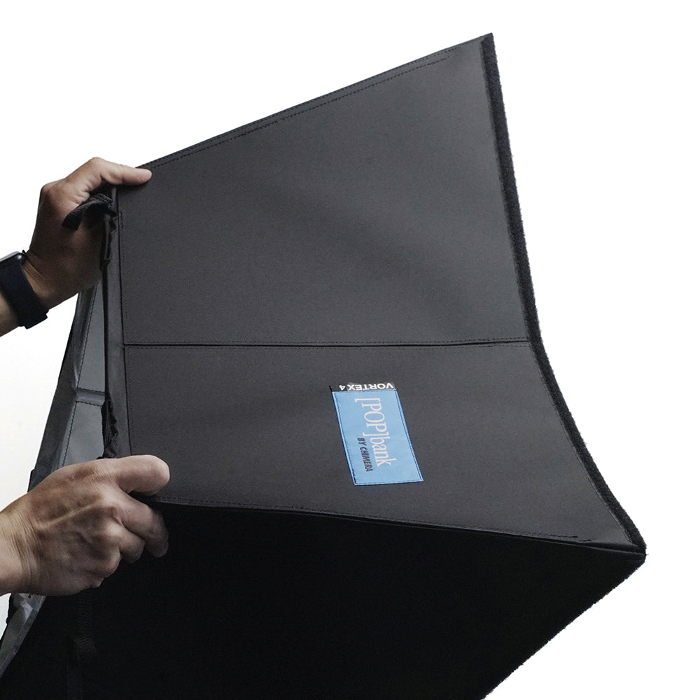 Hands holding a Small POP Bank for Vortex4, designed for photography lighting solutions.