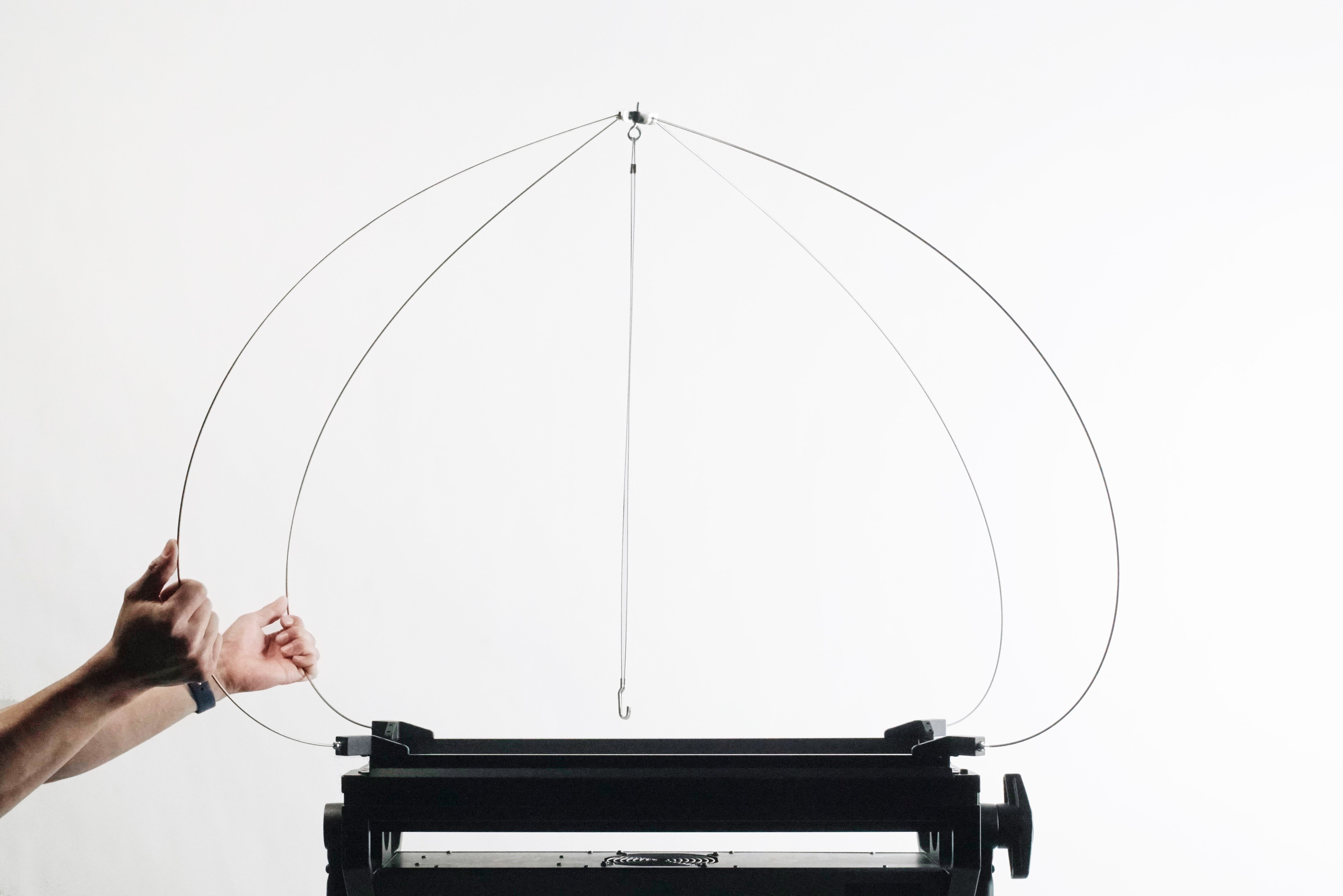 Hands adjusting a support rig for a Lantern designed for photography with 1x2 LED panels.